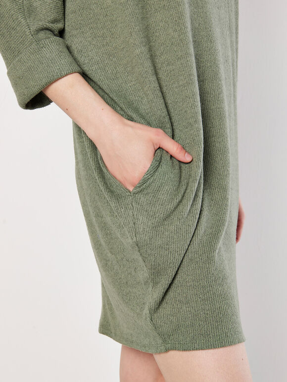 A greenish-brown knitted dress in a cocoon shape with ruffles along the edges